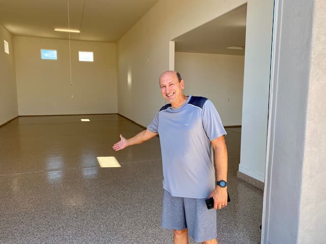 Happy Armor-Kote customer showing off a finished epoxy garage floor